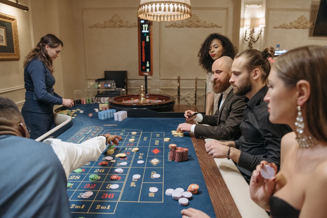 Meja roulette dengan dealer dan kartu permainan