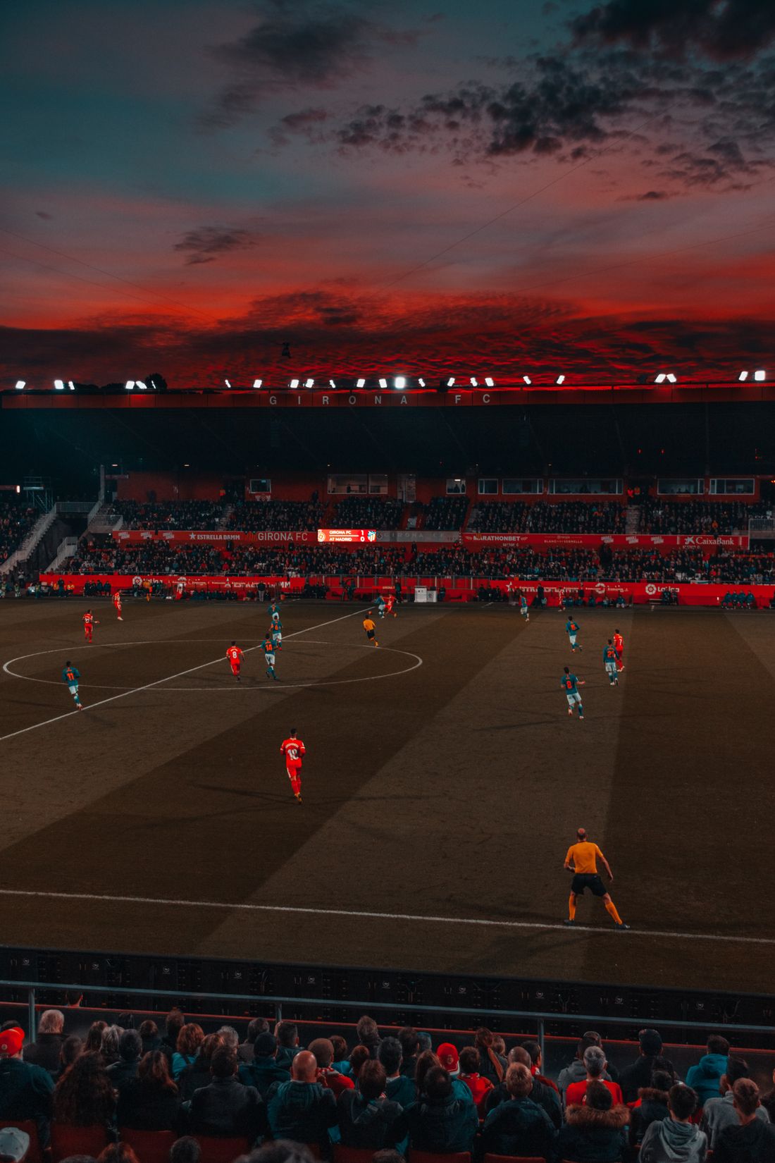Stadion sepak bola di malam hari dengan lampu sorot menyala